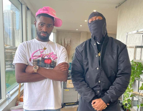 Two men standing in a room
AI-generated content may be incorrect.